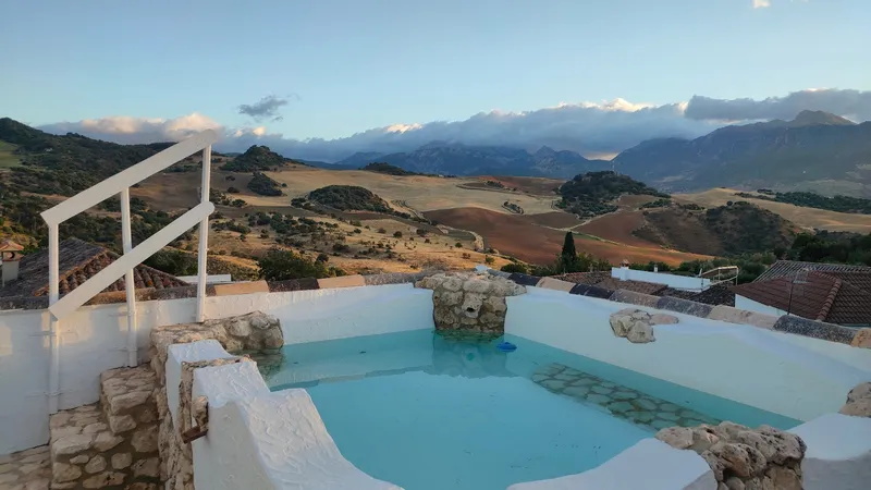 Paisaje montañoso con piscina tranquila.