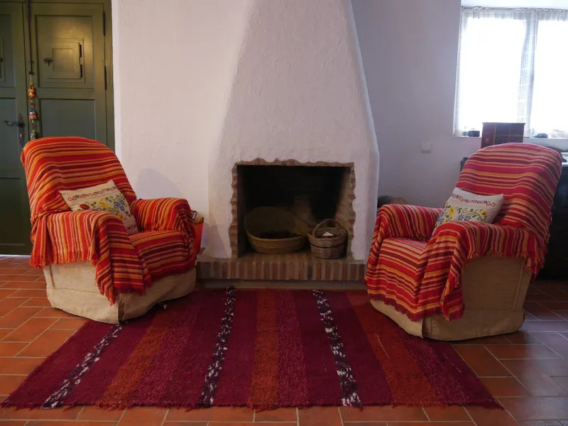 Sillones cómodos junto a chimenea.