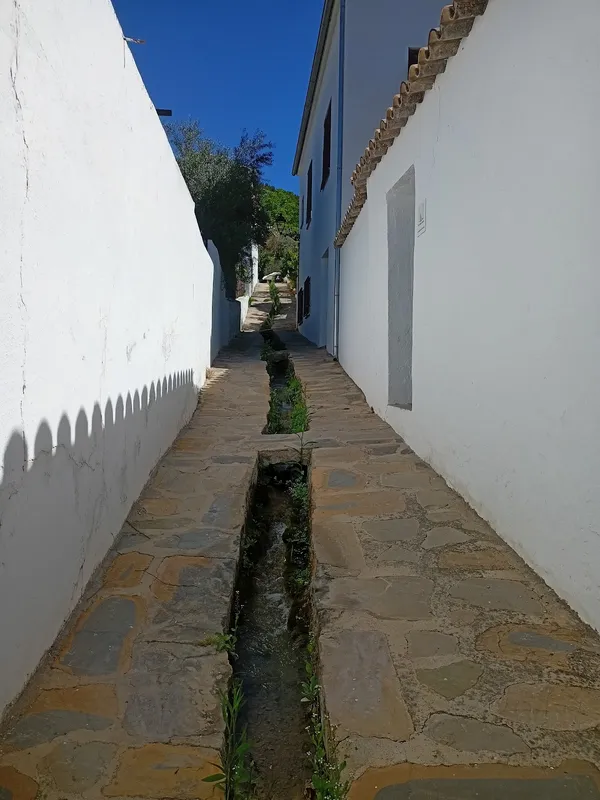 Calle estrecha con paredes blancas.