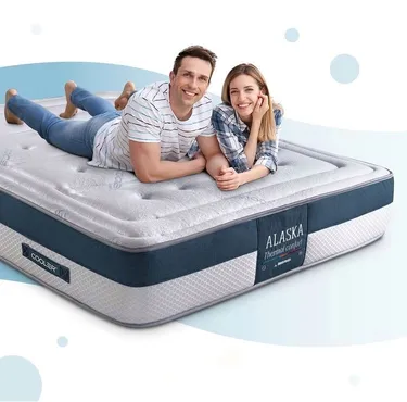 Pareja feliz sobre un colchón.