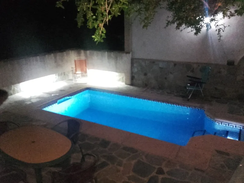 Piscina iluminada, ambiente nocturno.
