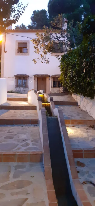 Casa blanca, jardín y agua.