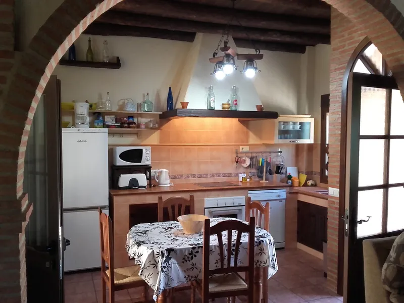 Cocina acogedora con mesa y electrodomésticos.