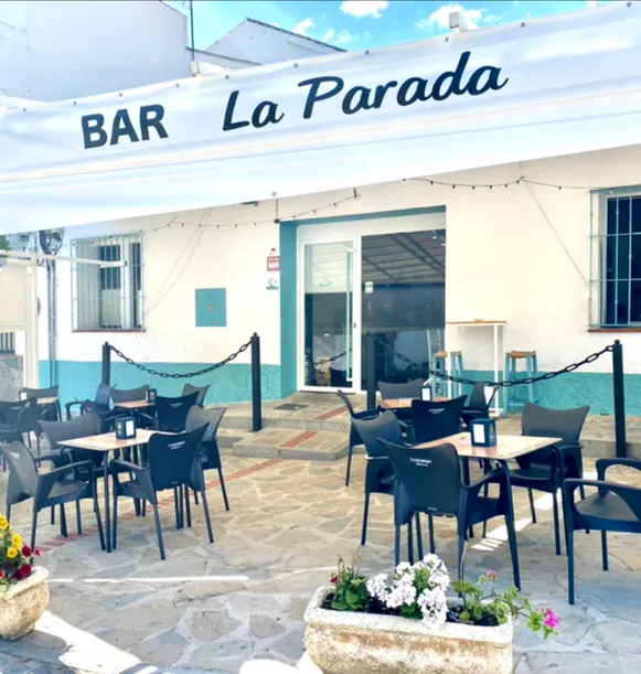 Bar pequeño con mesas afuera.