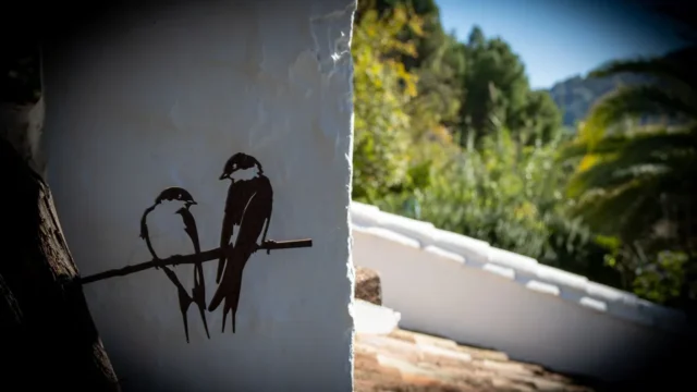 Pájaros de metal en rama.