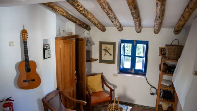 Sala acogedora con guitarra y ventana.