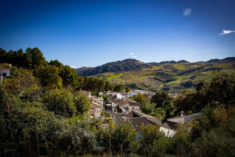 Pueblo tranquilo, montañas verdes, cielo.